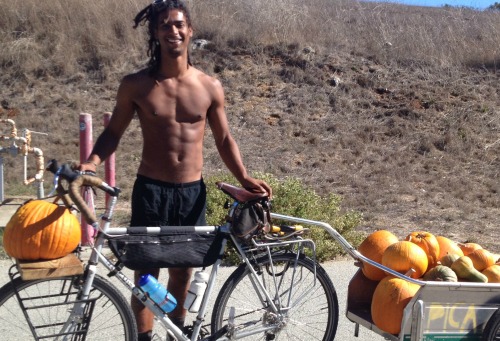 student with bike and trailer filled with squash